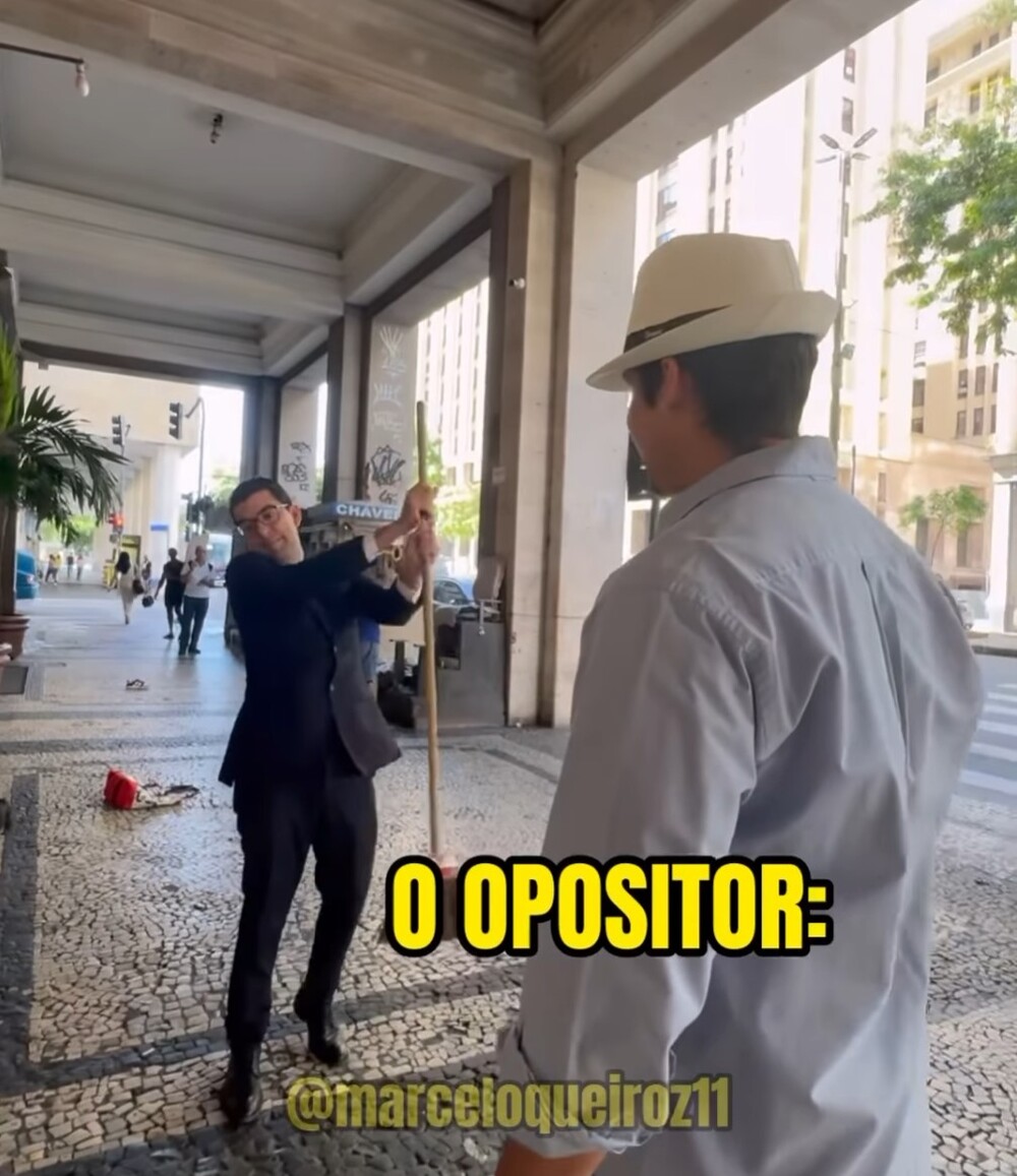 'Varre, varre, vassourinha...' Qual a mensagem Queiroz quis passar com sósia do Paes jogando vassoura nele?